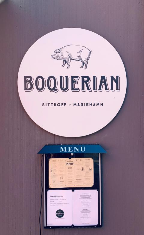 Bild på Boquerians logo samt menyskåp vid ytterväggen mot Torggatan.